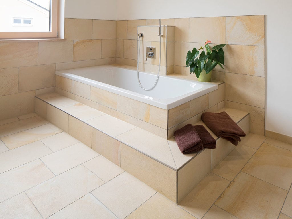Ein mit beigen Bodenplatten gefliestes Badezimmer mit Bdewanne
