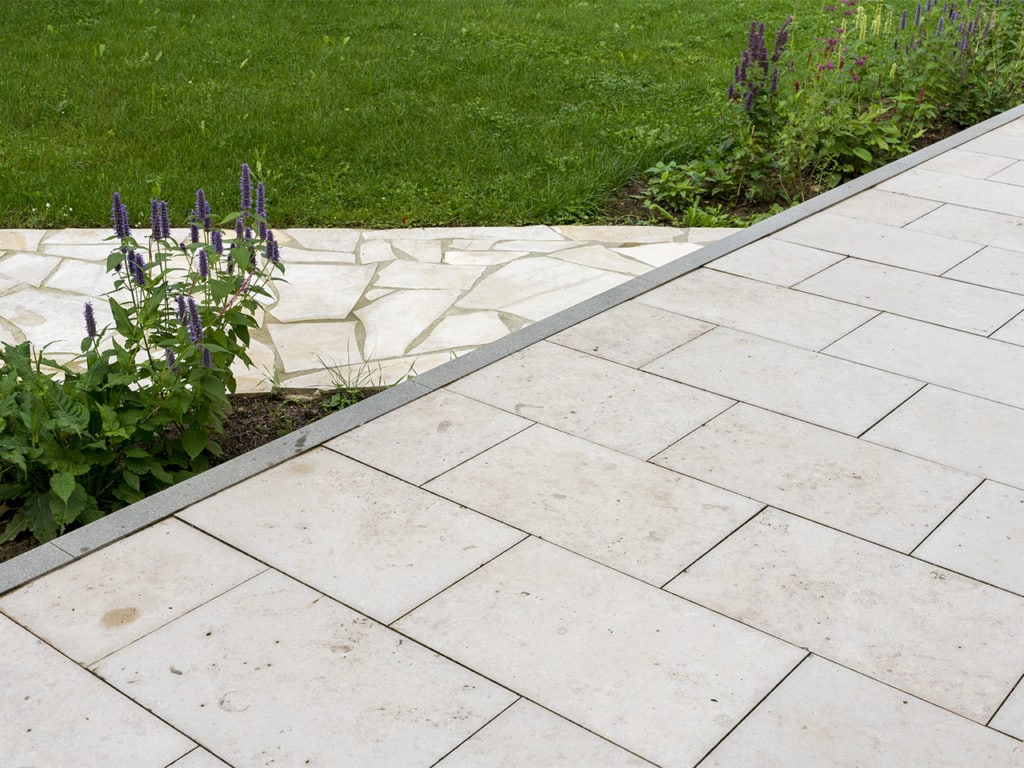 Helle Terrassenplatten aus Jura Marmor in einem Garten gepflastert